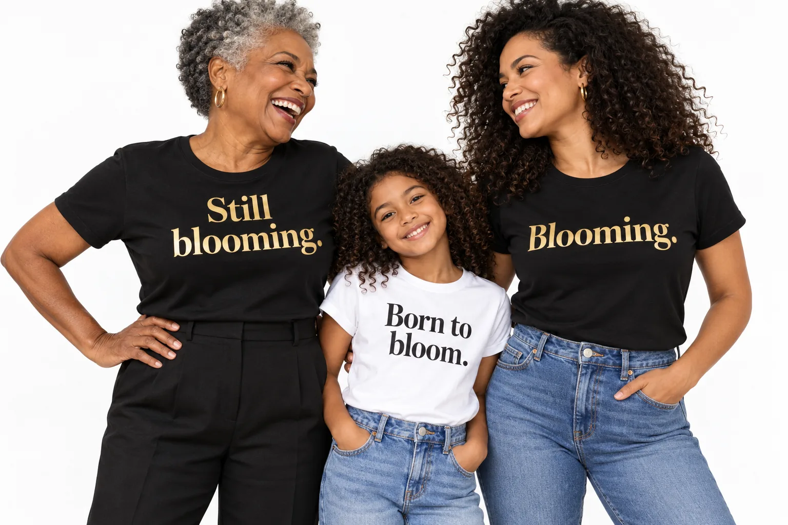 Campaign photo: a grandmother, mother and curly-haired daughter laughing together in their Still blooming., Blooming. and Born to bloom. T-shirts