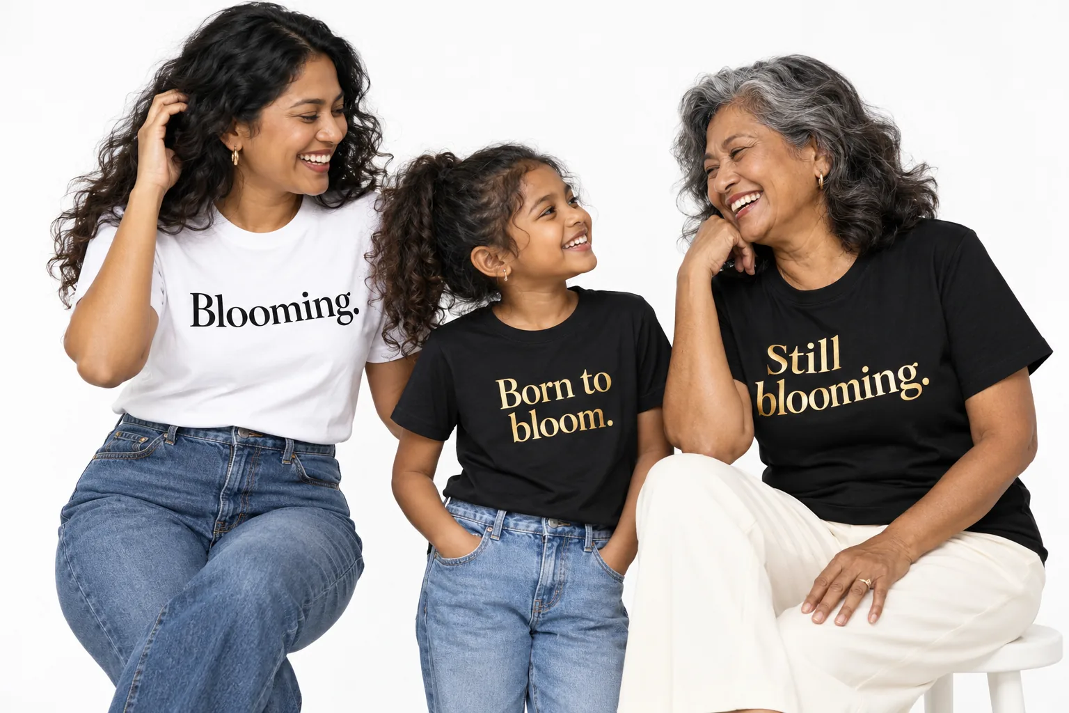 Campaign photo: a mother, daughter and grandmother in black and white Blooming., Born to bloom. and Still blooming. T-shirts